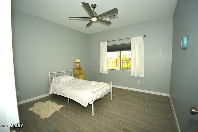 bedroom featuring ceiling fan, visible vents, baseboards, and wood finished floors