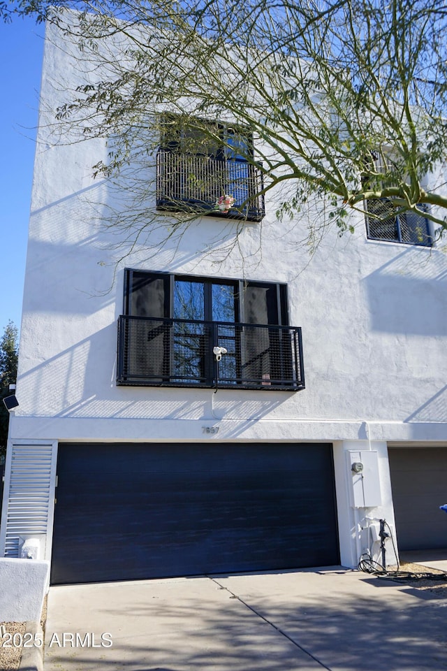 view of property exterior with a balcony and a garage