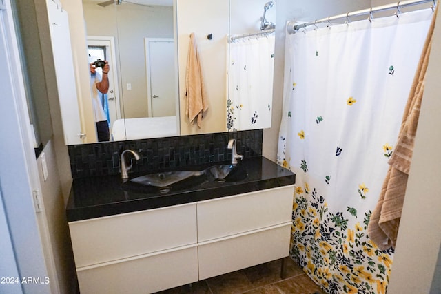 bathroom with decorative backsplash, curtained shower, and vanity