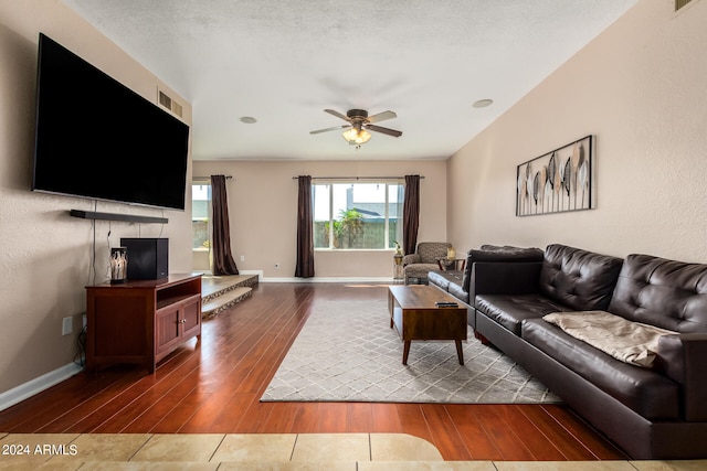 living room with hardwood / wood-style floors, a textured ceiling, and ceiling fan