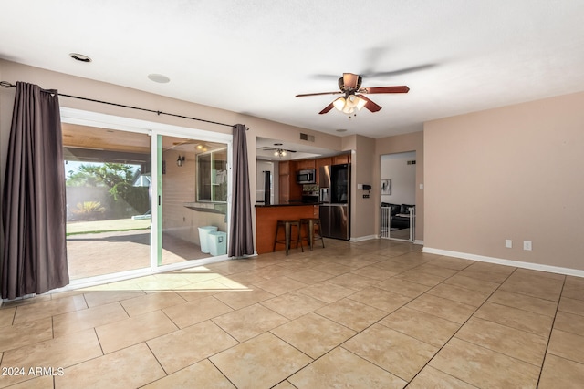 unfurnished living room with light tile patterned flooring and ceiling fan