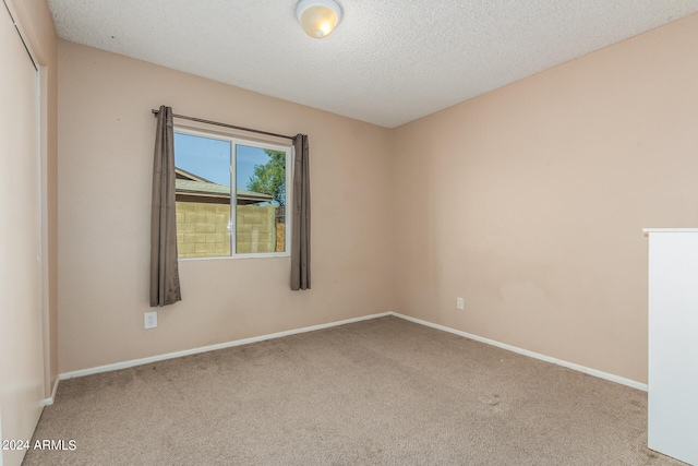 unfurnished room featuring carpet floors and a textured ceiling