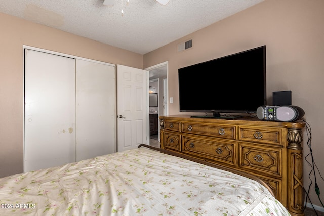 bedroom with ceiling fan, a closet, and a textured ceiling