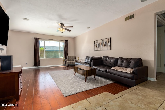 living room with hardwood / wood-style flooring, a textured ceiling, and ceiling fan