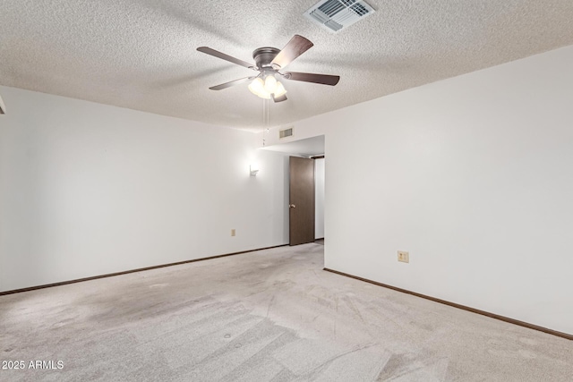 empty room featuring ceiling fan, light carpet, and a textured ceiling