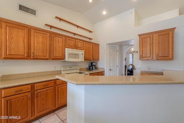 kitchen featuring light tile patterned flooring, sink, high vaulted ceiling, kitchen peninsula, and white appliances