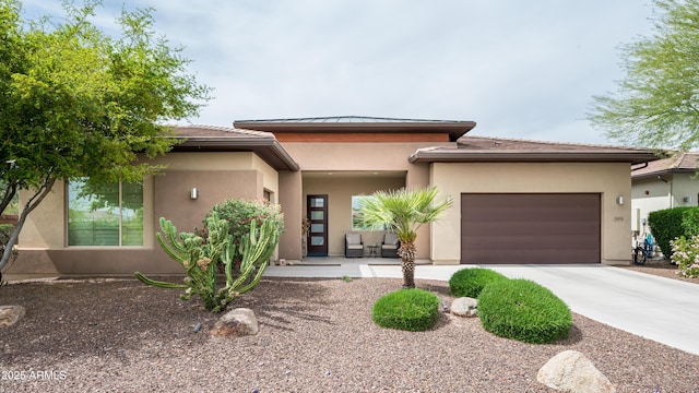 prairie-style house featuring an attached garage, driveway, and stucco siding