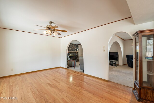 3109 N 81st St, Scottsdale, AZ 85251 - empty room featuring ceiling fan, arched walkways, light wood-style flooring, baseboards, and crown molding