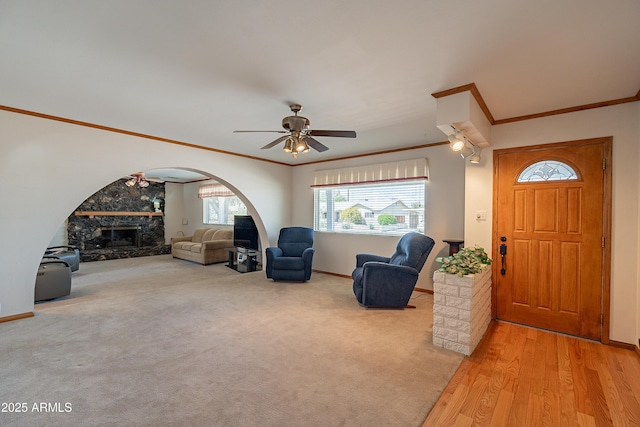 3109 N 81st St, Scottsdale, AZ 85251 - foyer with crown molding, ceiling fan, arched walkways, baseboards, and a stone fireplace