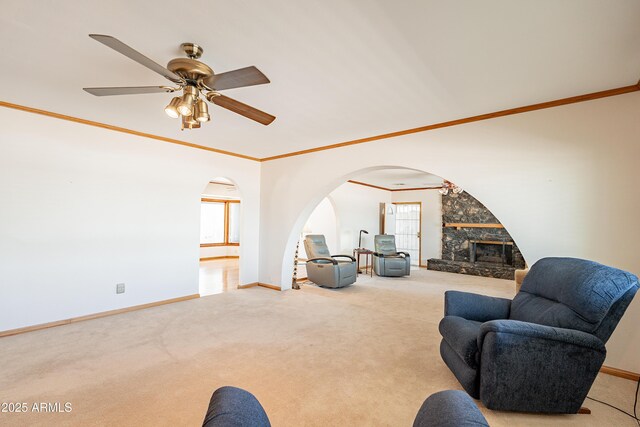 3109 N 81st St, Scottsdale, AZ 85251 - carpeted living area with arched walkways, crown molding, a ceiling fan, baseboards, and a fireplace