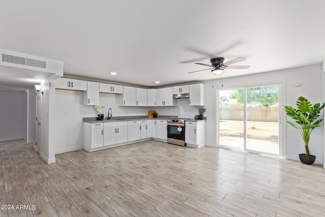 kitchen featuring light wood-type flooring, ceiling fan, stainless steel electric stove, sink, and white cabinetry