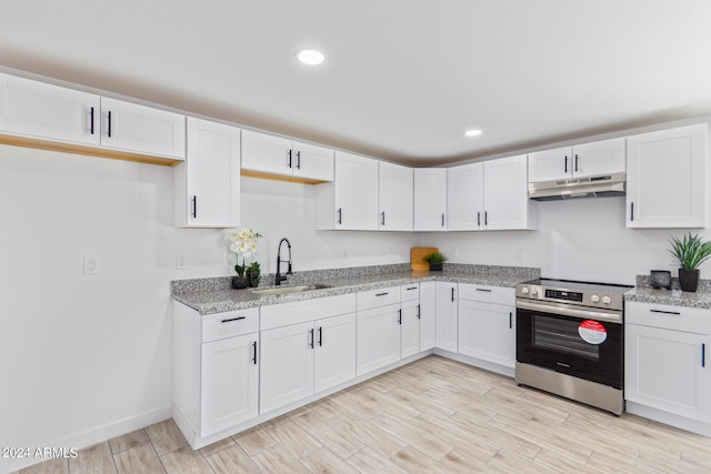 kitchen featuring stainless steel range with electric stovetop, sink, and white cabinetry