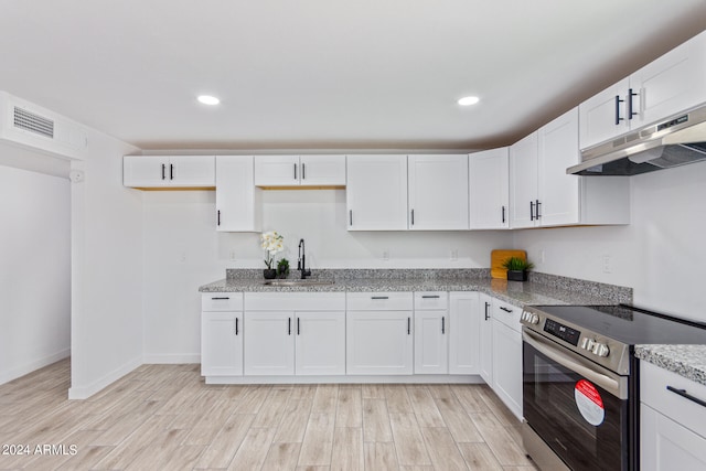 kitchen with electric range, white cabinets, sink, and light wood-type flooring