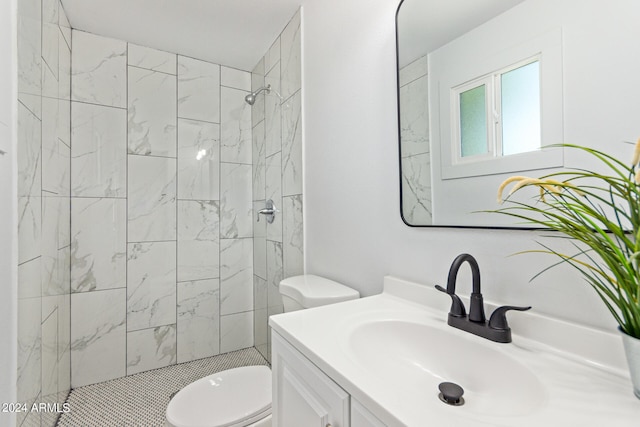 bathroom featuring tiled shower, vanity, and toilet