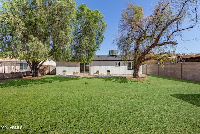 rear view of house featuring a lawn