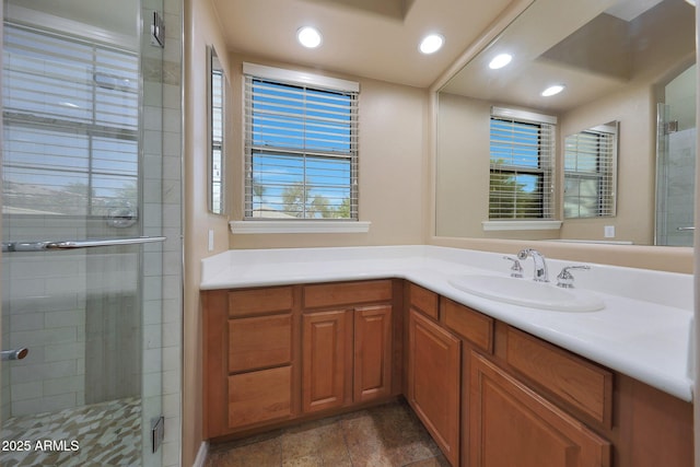 full bathroom with a stall shower, vanity, and recessed lighting