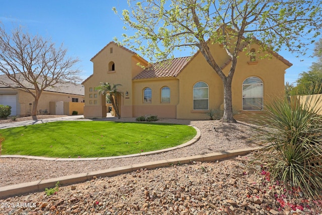 mediterranean / spanish-style home with a tiled roof, a front lawn, and stucco siding