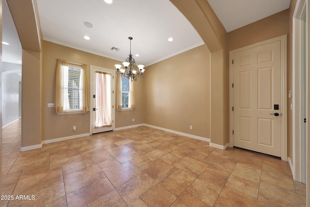 entrance foyer featuring arched walkways, crown molding, an inviting chandelier, and baseboards