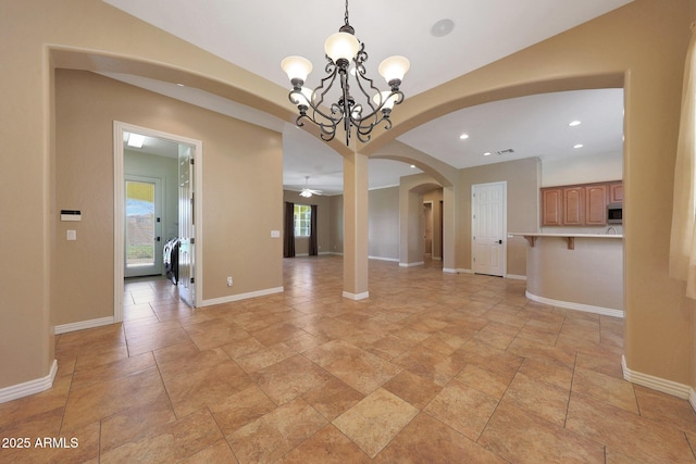 unfurnished dining area with arched walkways, recessed lighting, an inviting chandelier, and baseboards