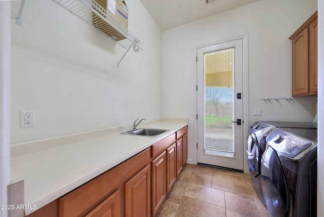 clothes washing area with cabinet space, separate washer and dryer, and a sink