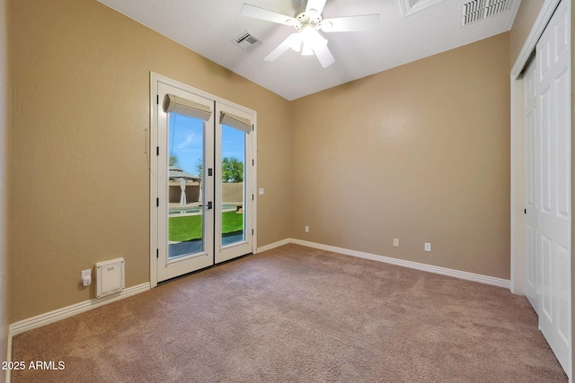 carpeted empty room featuring visible vents, ceiling fan, and baseboards