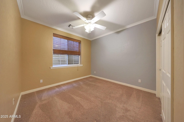 unfurnished room featuring ornamental molding, carpet flooring, visible vents, and baseboards