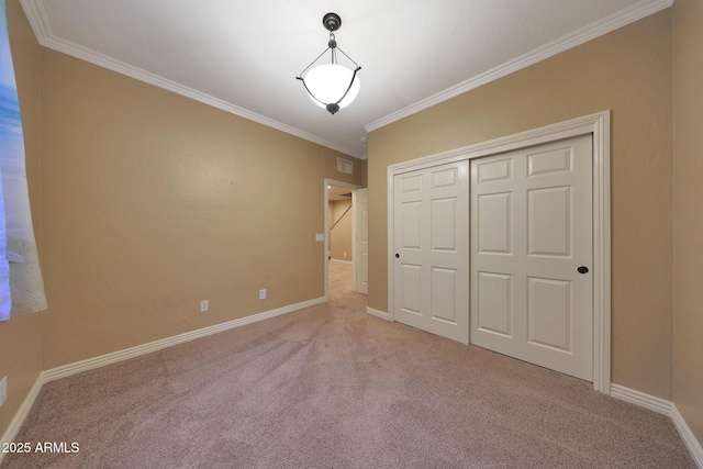 unfurnished bedroom featuring baseboards, visible vents, carpet, crown molding, and a closet