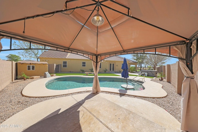 view of swimming pool featuring a patio, a gazebo, a fenced backyard, and a fenced in pool