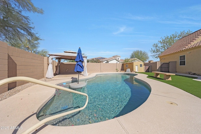 view of swimming pool with a fenced in pool, an outbuilding, a patio area, and a fenced backyard