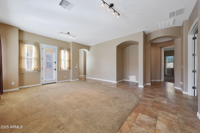 interior space with arched walkways, visible vents, and baseboards