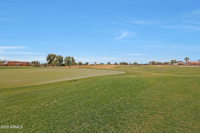 surrounding community with view of golf course and a lawn