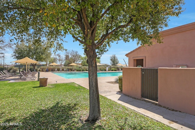 community pool featuring a yard, a patio area, and fence