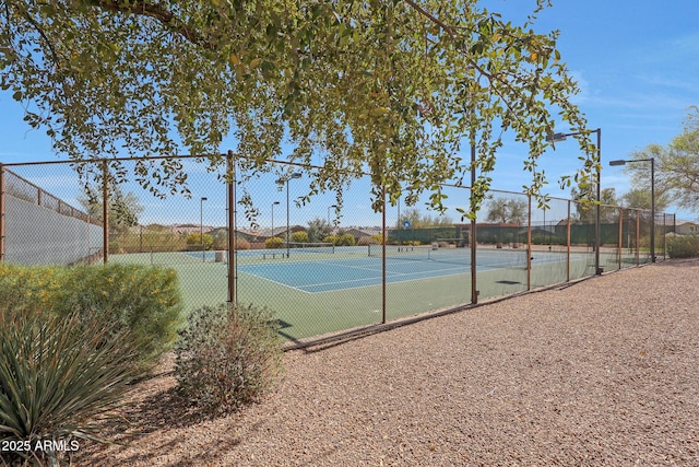 view of tennis court featuring fence