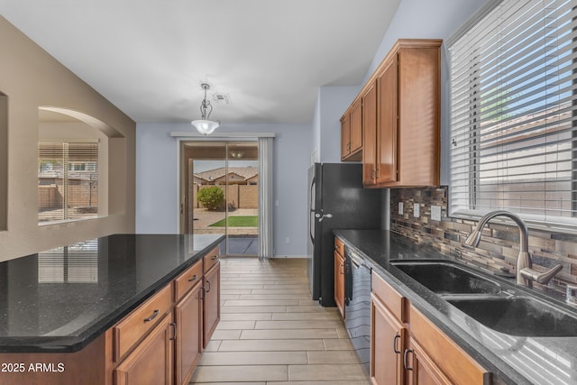 kitchen with a wealth of natural light, decorative backsplash, and a sink