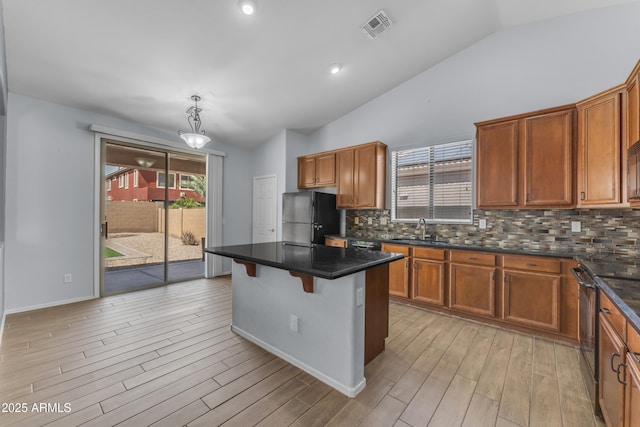 kitchen featuring light wood finished floors, freestanding refrigerator, visible vents, stainless steel electric range oven, and lofted ceiling