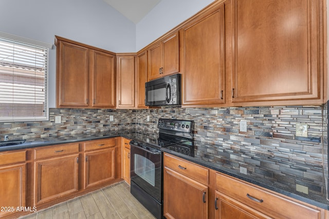 kitchen with brown cabinets, dark stone counters, black appliances, backsplash, and lofted ceiling