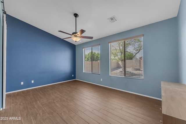 spare room with wood finished floors, baseboards, and ceiling fan