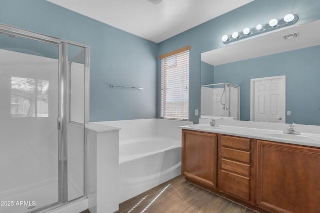 full bath featuring visible vents, a sink, a shower stall, a garden tub, and double vanity