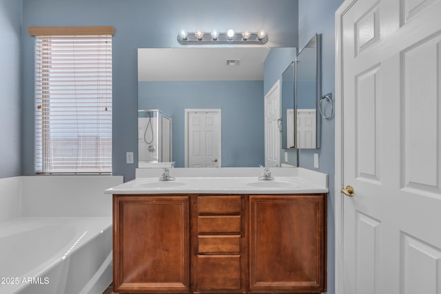 full bathroom with a shower stall, a garden tub, double vanity, and a sink