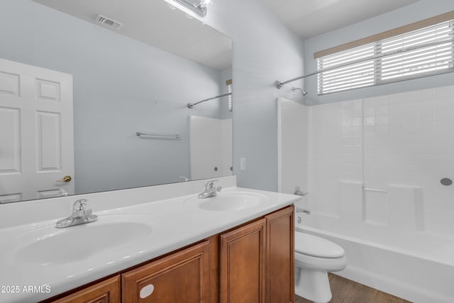 bathroom featuring a sink, double vanity, toilet, and visible vents