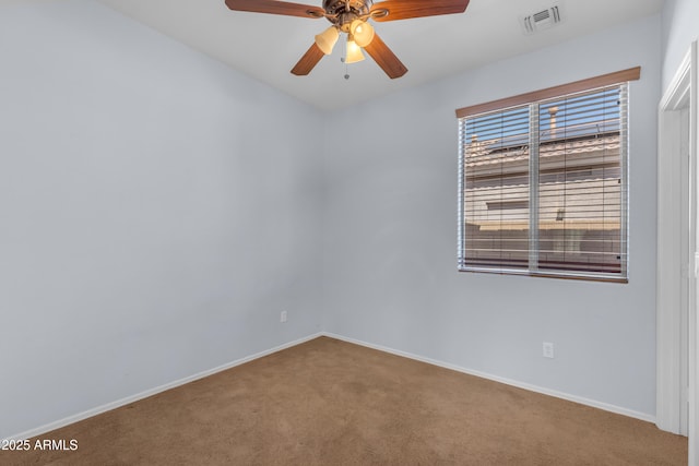 carpeted spare room featuring baseboards, ceiling fan, and visible vents