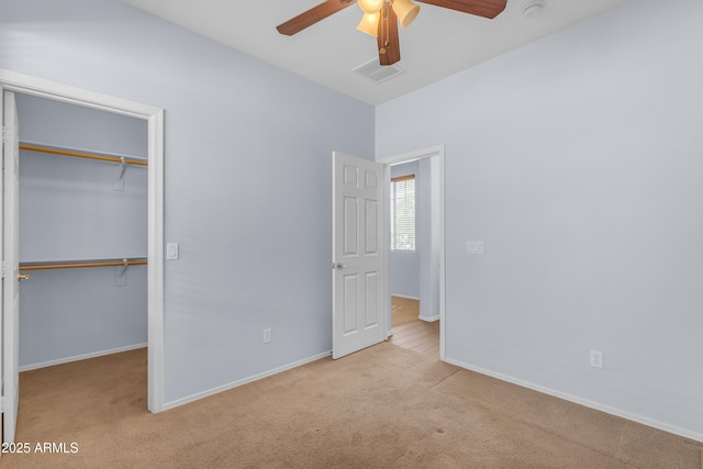 unfurnished bedroom with a closet, carpet, baseboards, ceiling fan, and visible vents