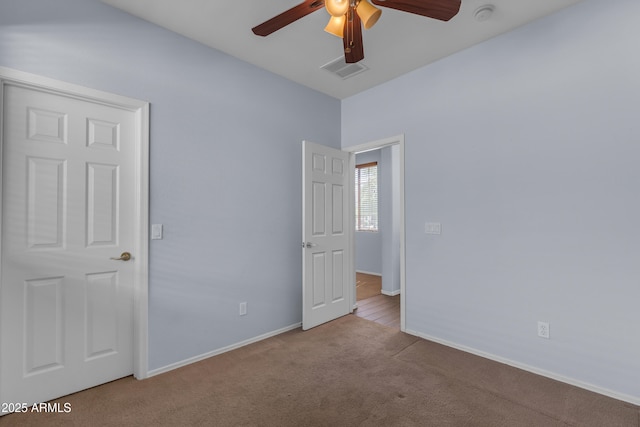 unfurnished bedroom with carpet flooring, visible vents, baseboards, and ceiling fan