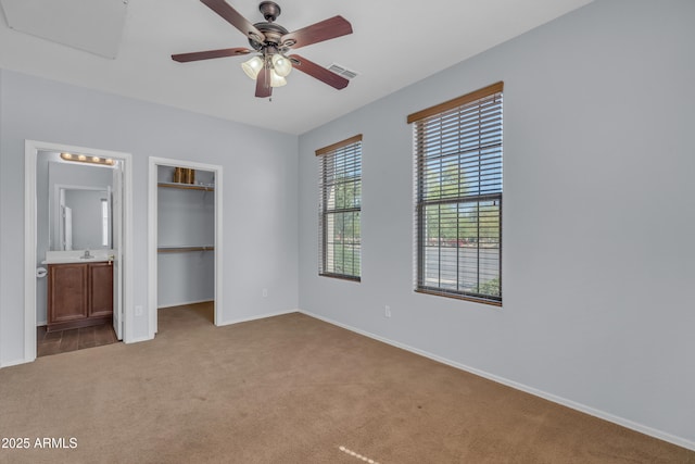 unfurnished bedroom featuring baseboards, a spacious closet, visible vents, and carpet