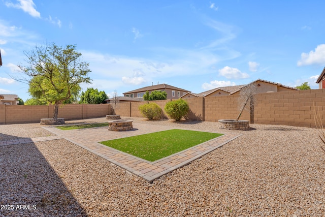 view of yard featuring an outdoor fire pit, a patio, and a fenced backyard