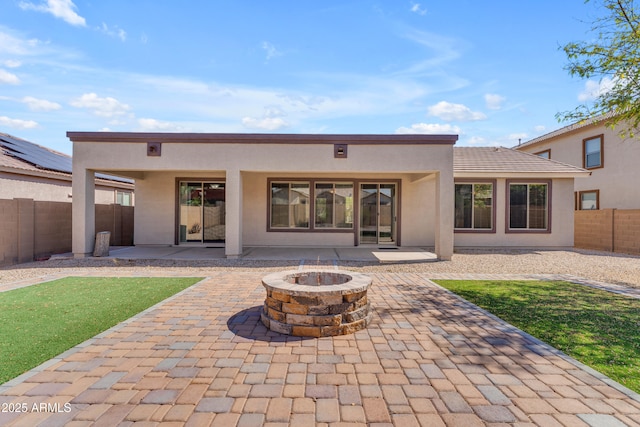 rear view of house featuring an outdoor fire pit, a patio, stucco siding, and a fenced backyard