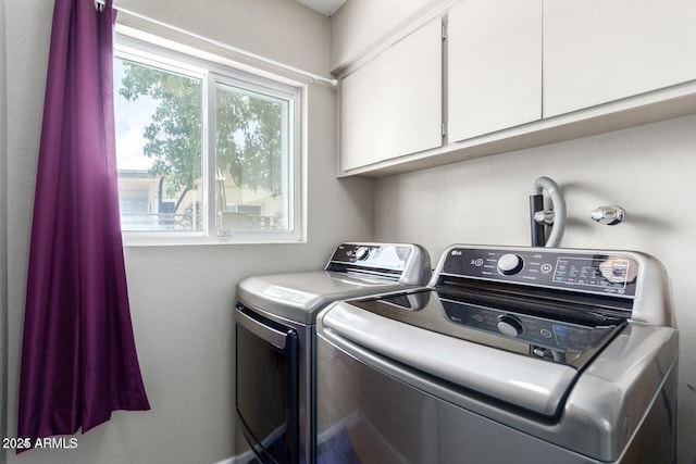 laundry room featuring cabinets, separate washer and dryer, and plenty of natural light