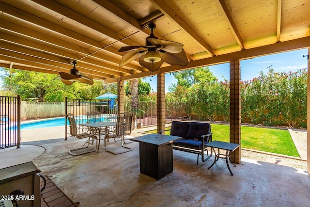 view of patio / terrace featuring a fenced in pool, an outdoor living space, and ceiling fan