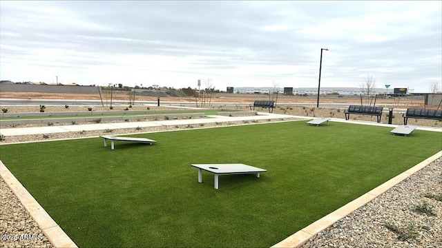 view of community featuring a yard and fence