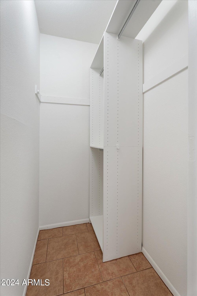 spacious closet with light tile patterned floors